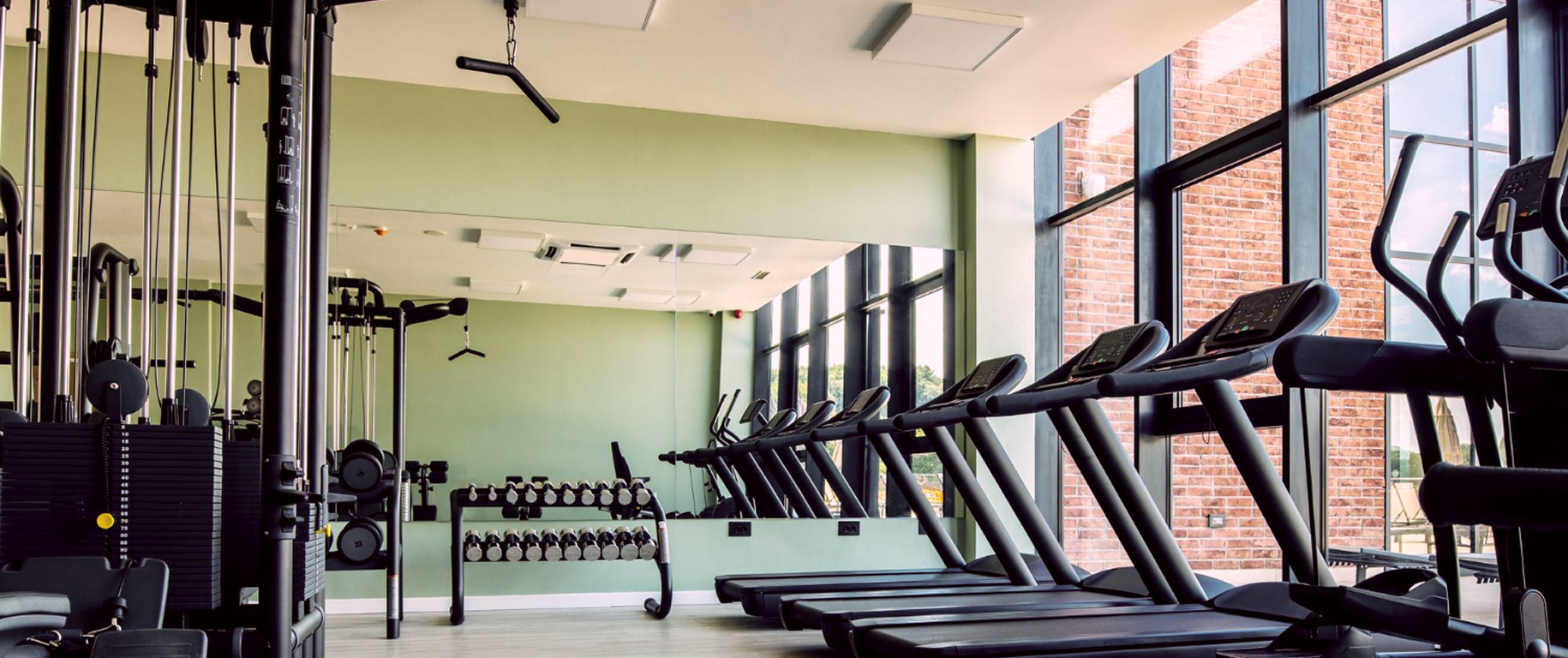 на фото изображен новый тренажерный зал с ремонтом и с новыми тренажерами беговые дорожки гантели и тяга верхнего блока